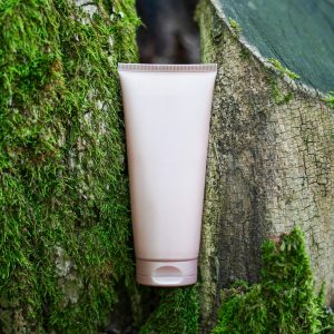 Cosmetic skin care product (body lotion, hair shampoo, face creme) on green nature background